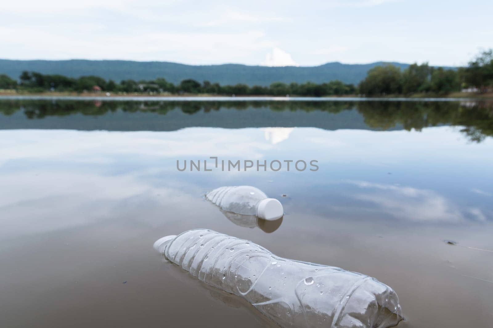 Plastic water bottles pollution in the river. Plastic trash in water. Environmental pollution concept.