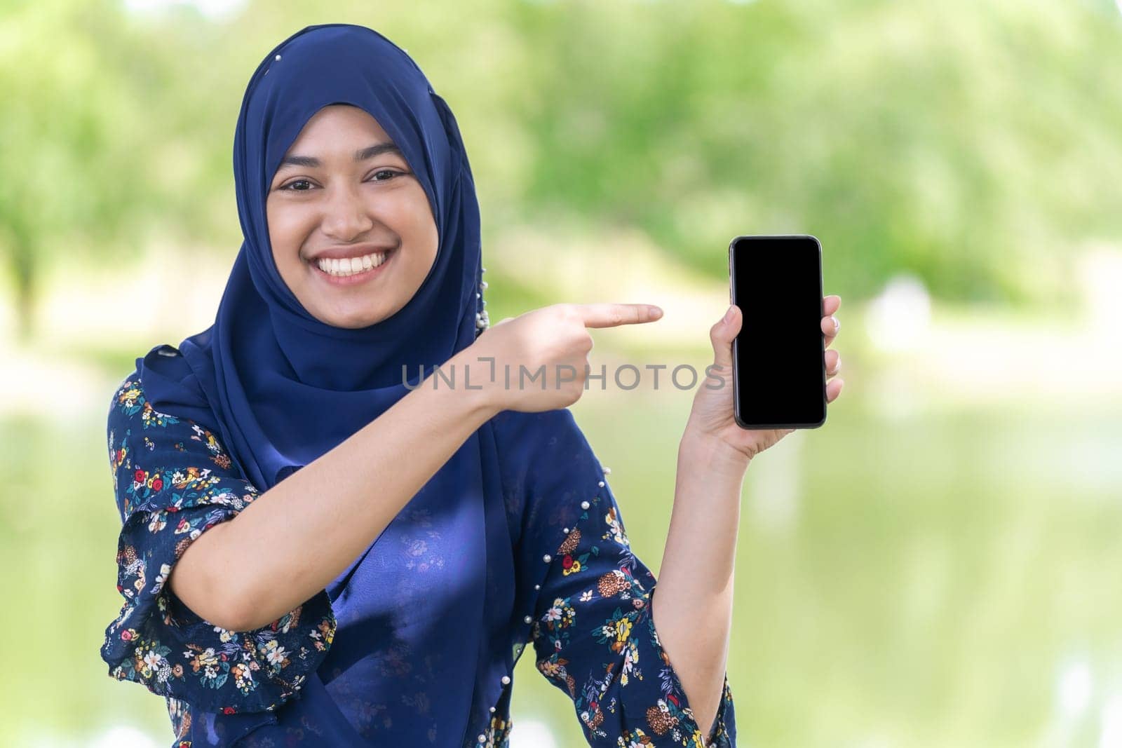 Portrait of good-looking Happy young teenager Muslim islamic asian university girl hold mobile phone