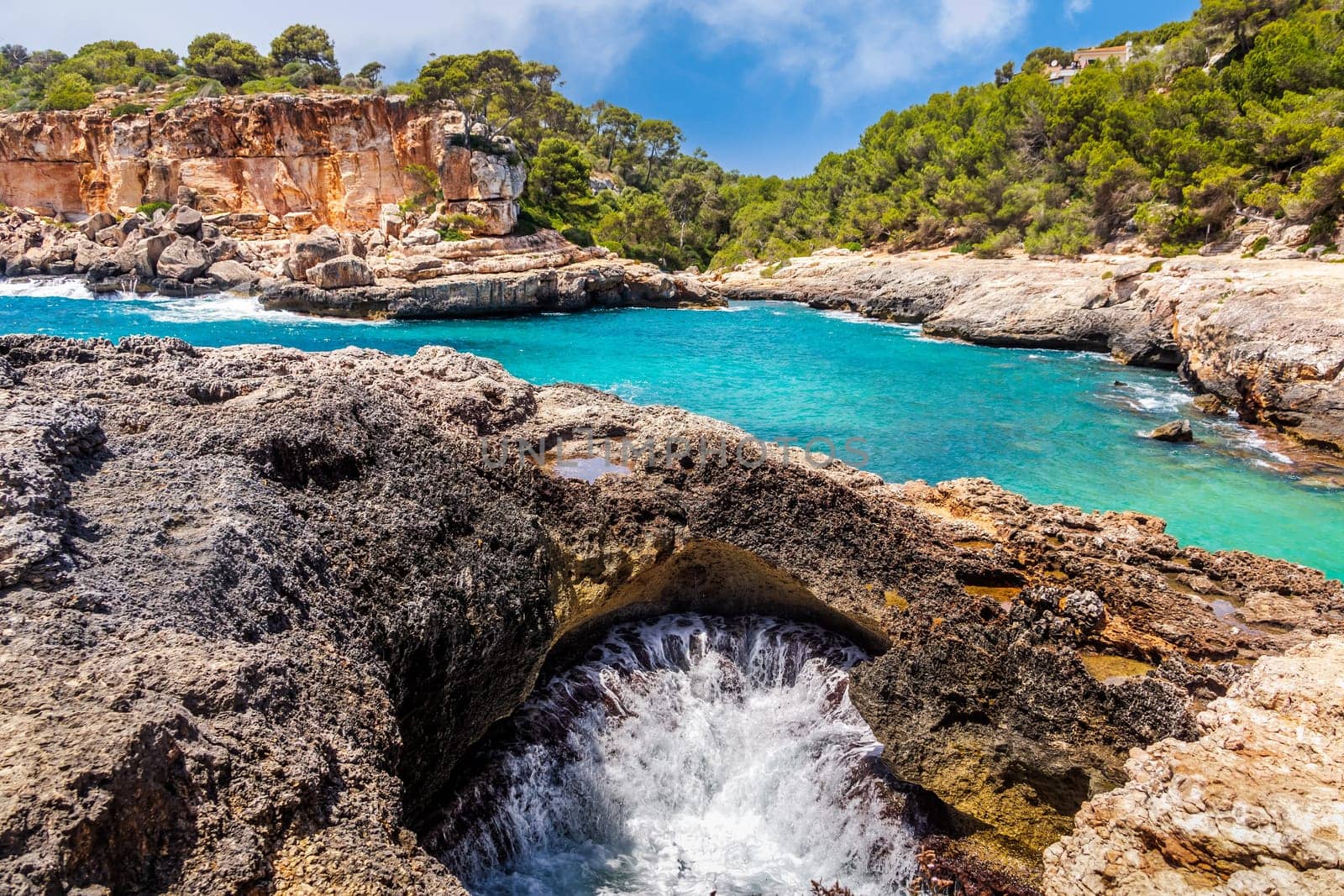 Panorama of beautiful beach and bay with cliffs, trees and turquoise sea water, Cala sAlmunia, Santanyi, Mallorca island, Spain