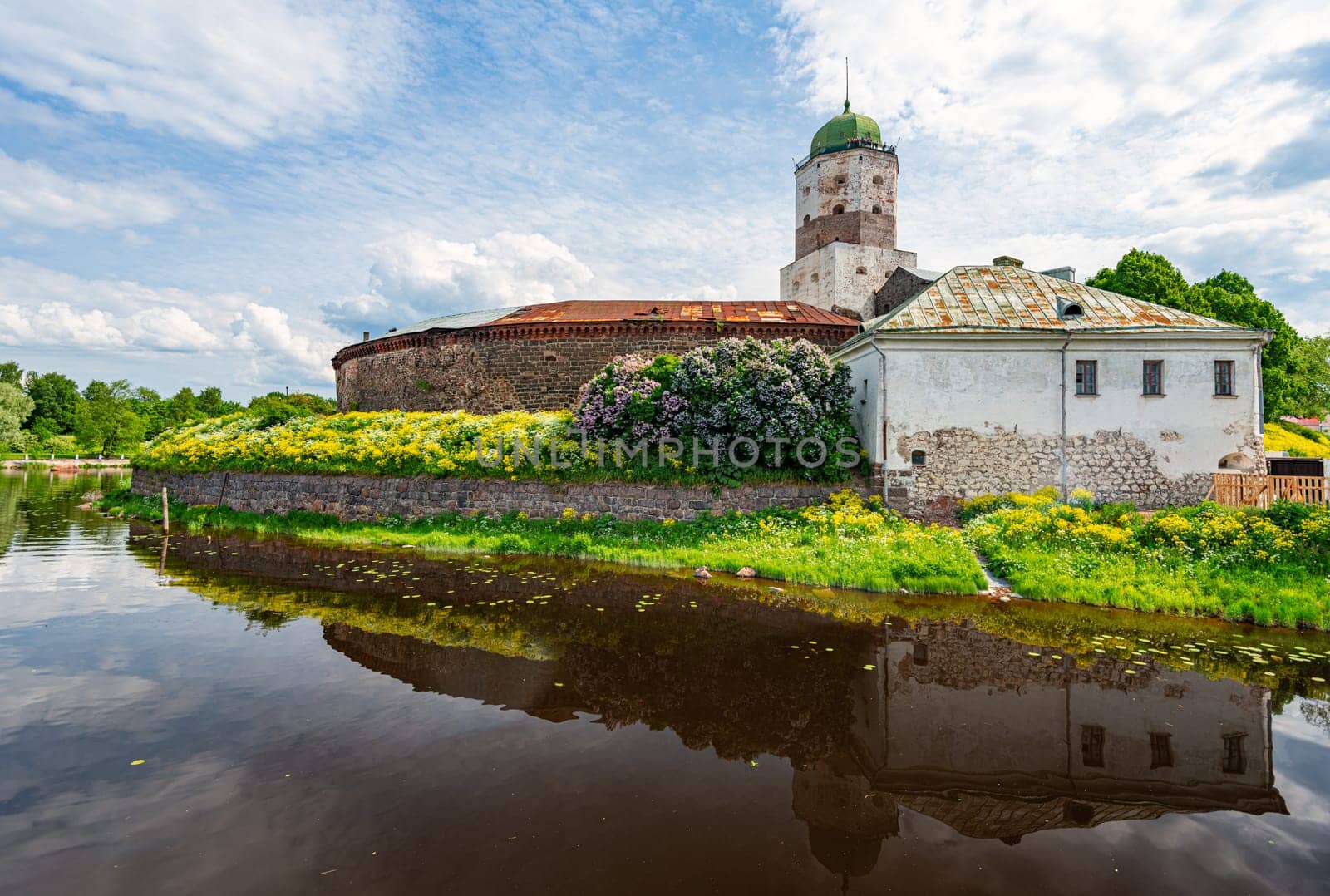 Architecture of old town Vyborg, Russia, Europe. Saint Olaf tower and Vyborg castle on summer day. Lake in foreground and sky in background
