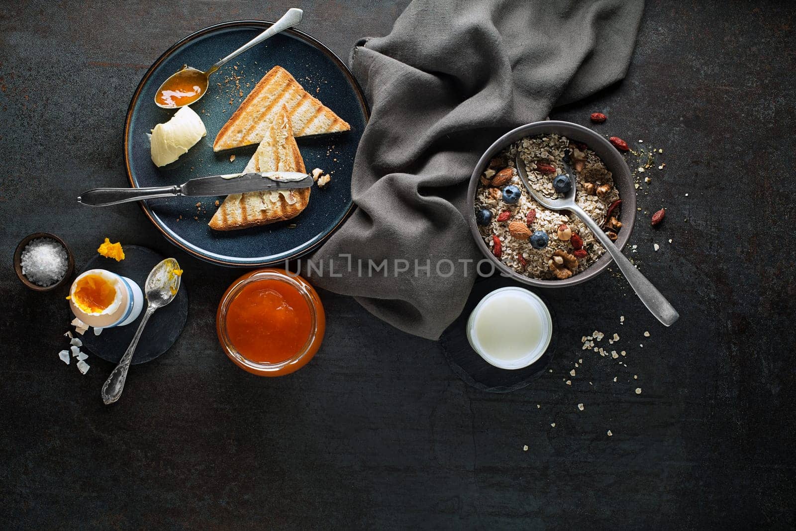 Breakfast served with oatmeal and fruits, boiled egg, jam and butter. Delicious healthy breakfast.