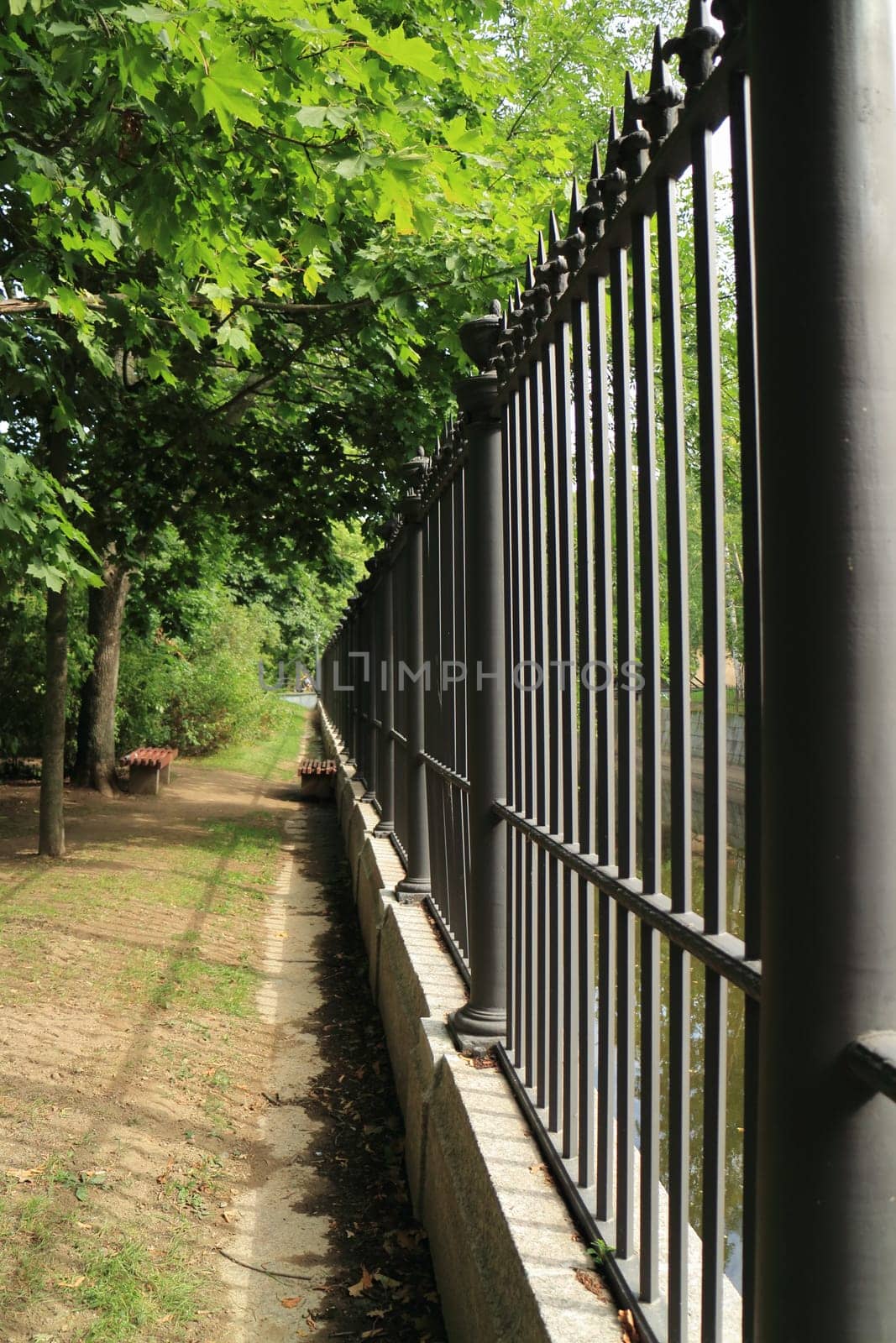 path along high steel  fence going straight into the distance