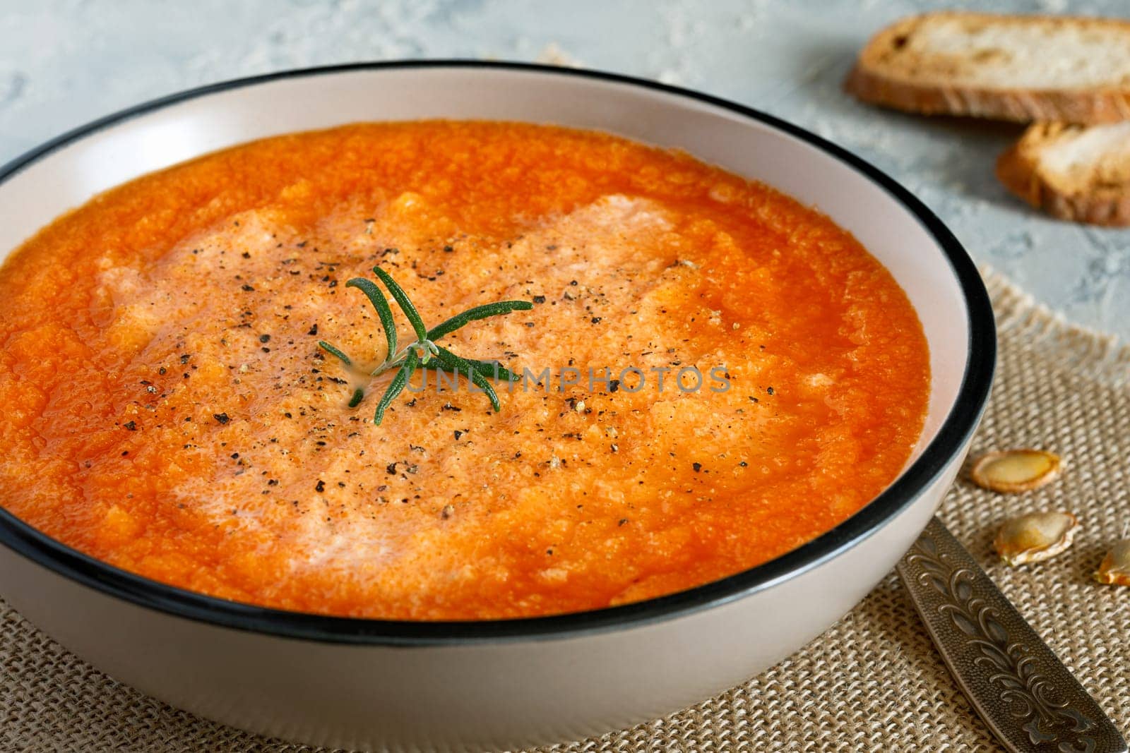 Pumpkin cream soup with cream, crackers and oregano