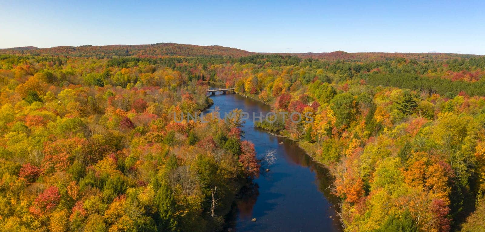Fall color is more saturated at sunset over the Oswegatche River Adirondack Park Mountains New York