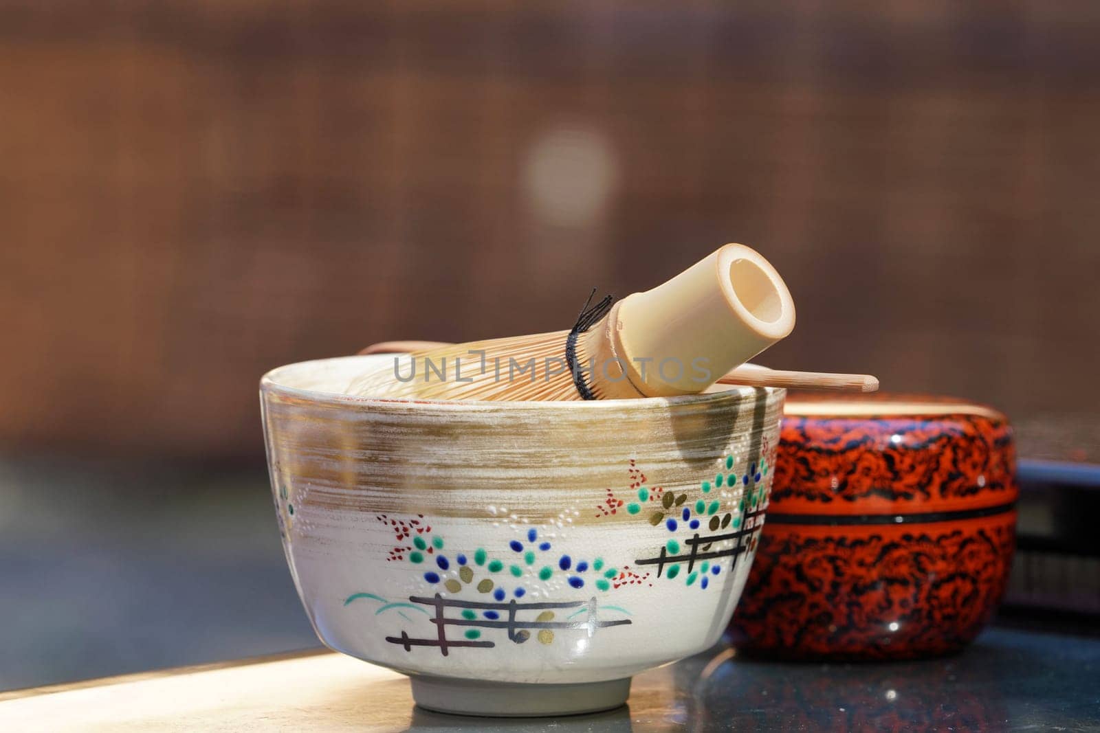 Japanese matcha green tea in a ceramic bowl with tea whisk