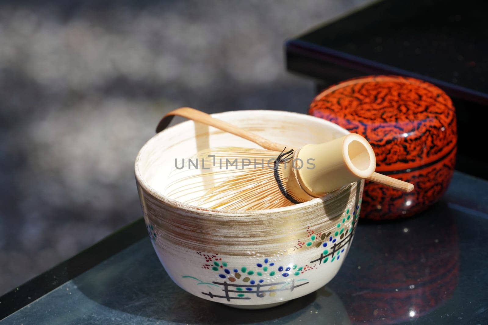 Japanese matcha green tea in a ceramic bowl with tea whisk
