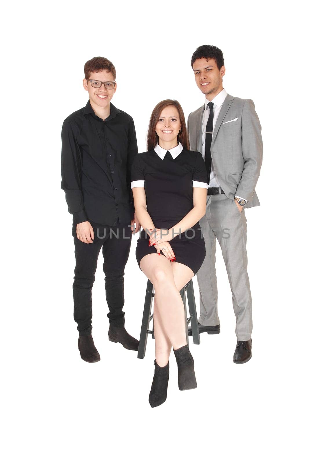 A family photo of three siblings, two boys and a girl, standing in a .studio, isolated for white background.