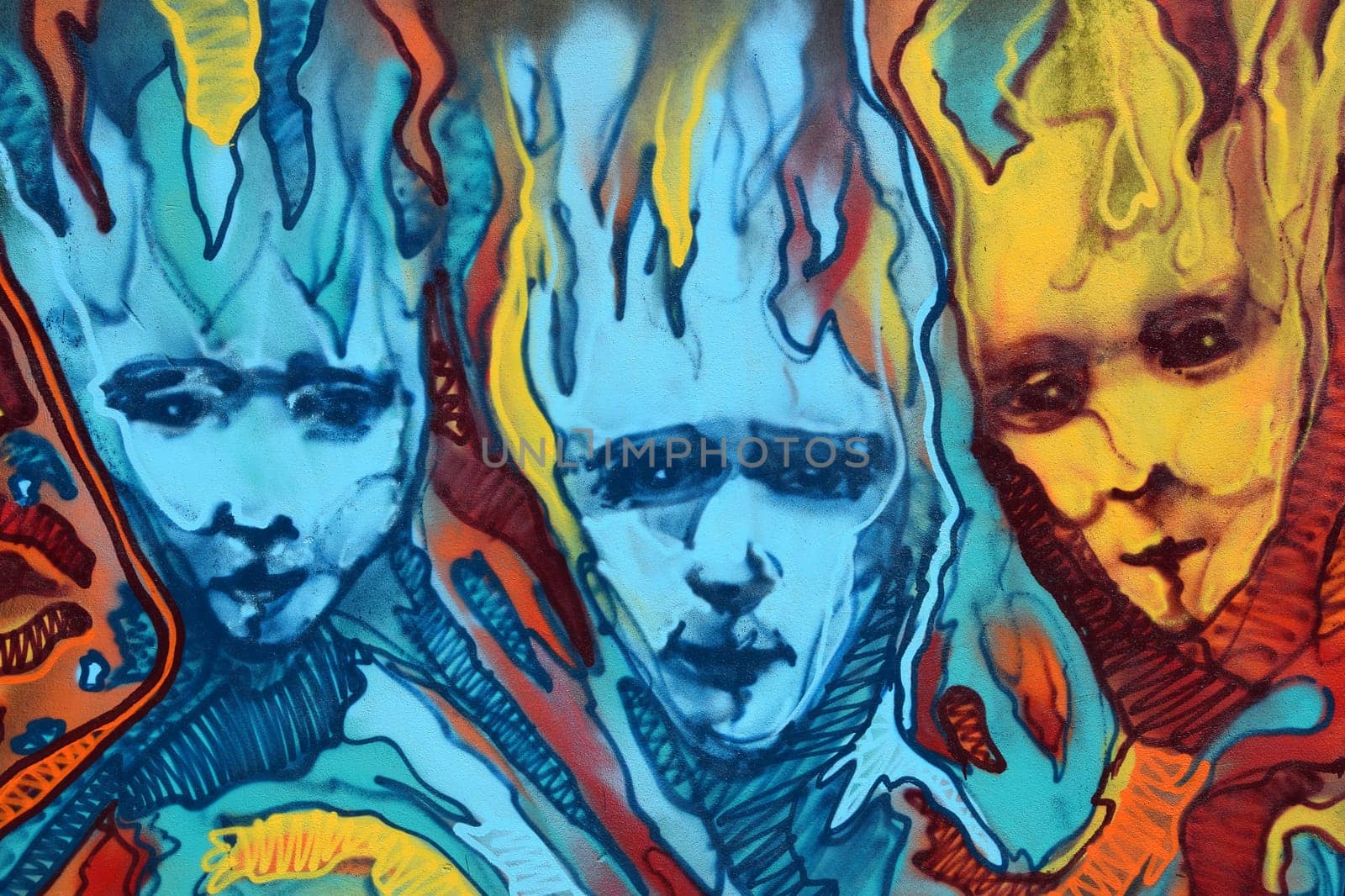 ATHENS, GREECE - APRIL 27, 2015: Abstract graffiti three distorted faces with flames. Colorful urban street art.