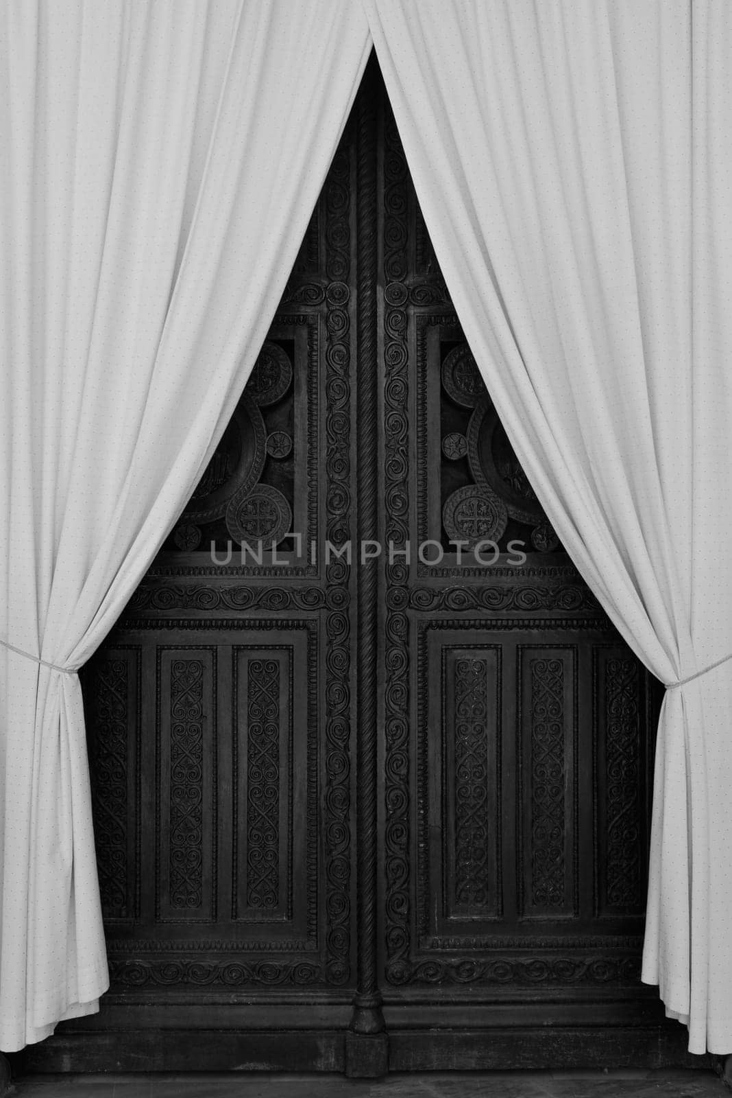 ATHENS, GREECE - APRIL 27, 2015: Antique wooden carved gate and drapes during repairs at the Metropolitan Cathedral of Athens, Greece. Black and white.