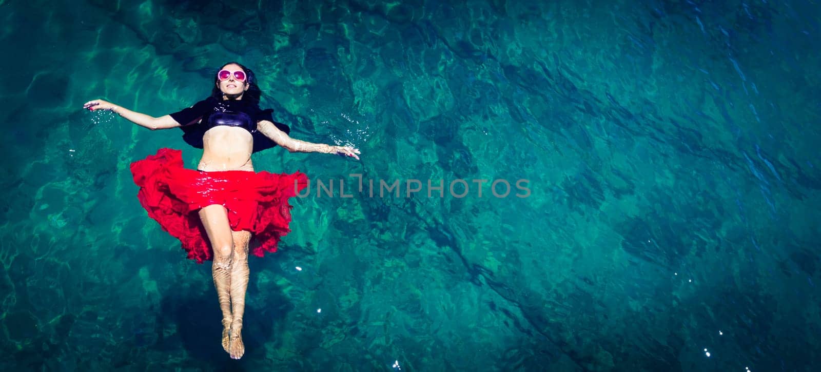 Aerial view of a beautiful woman dancing  in the sea