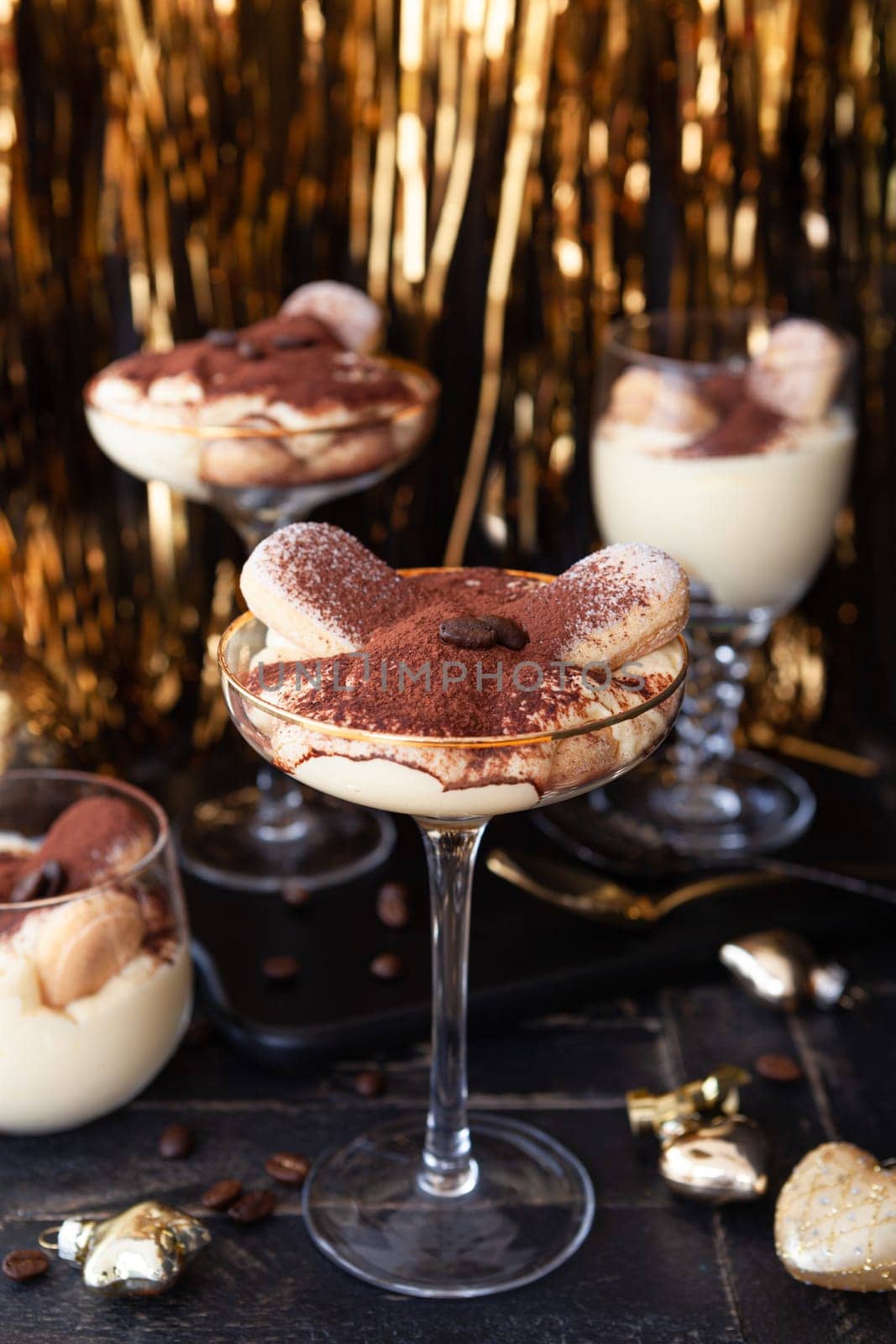 Festive tiramisu dessert in glasses with golden decorations for the holidays