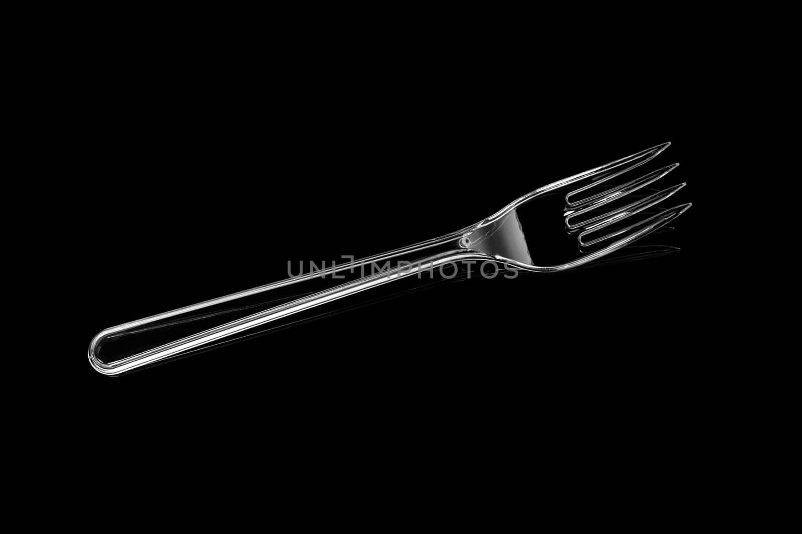 Transparent plastic fork isolated on black background. With clipping path