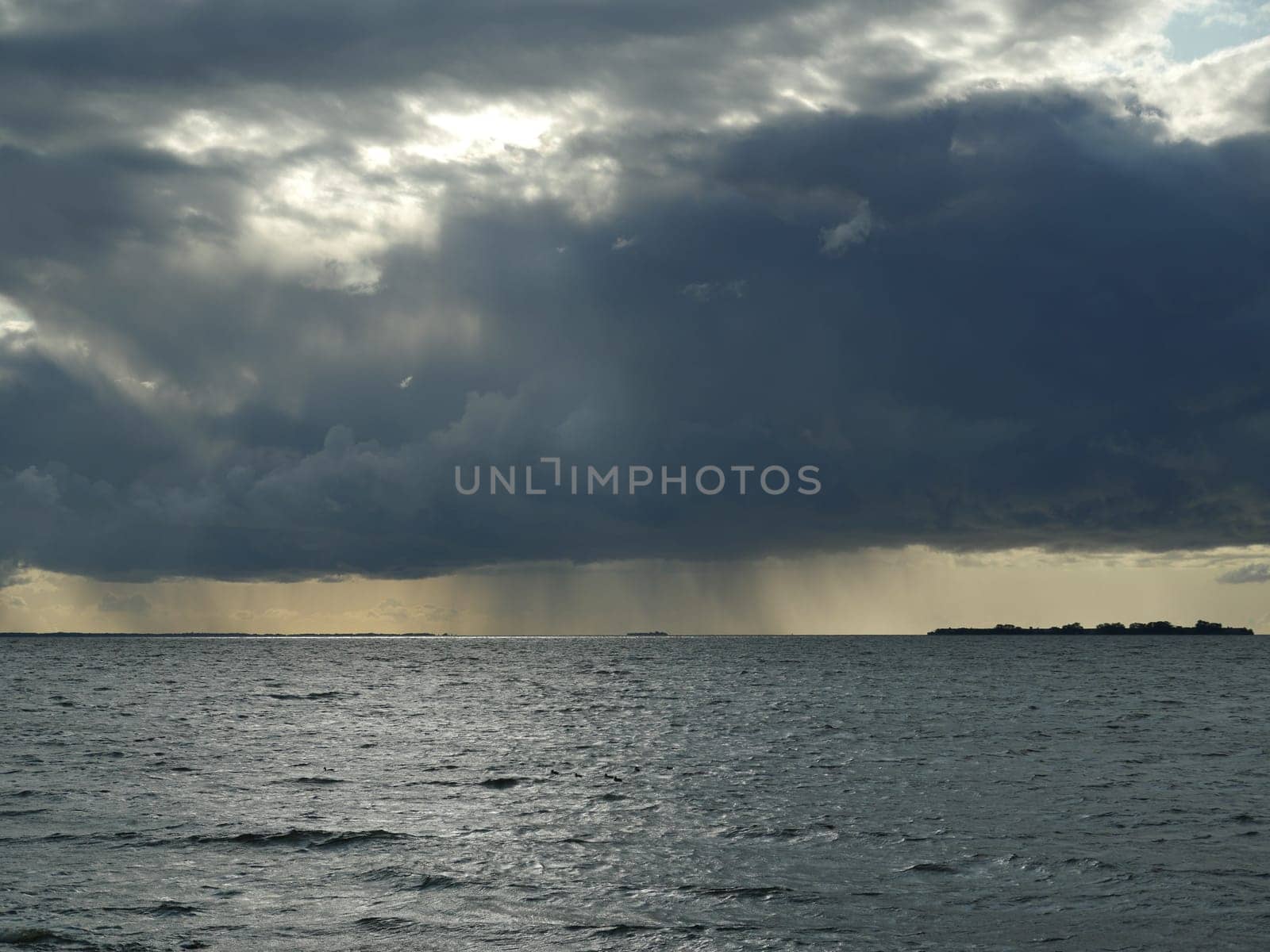 cyclone, a huge black cloud pours rain on the sea