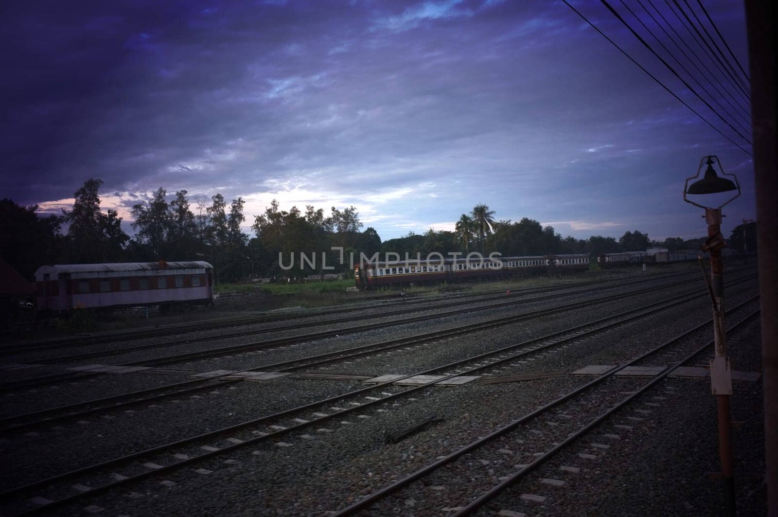 A colorful sunup above a small train station in thailand