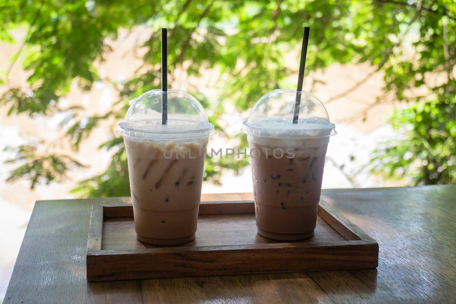Iced coffee on wooden outdoors table, stock photo
