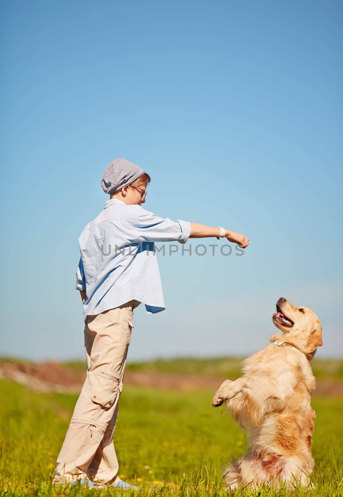 Teenage boy training his pet outdoors