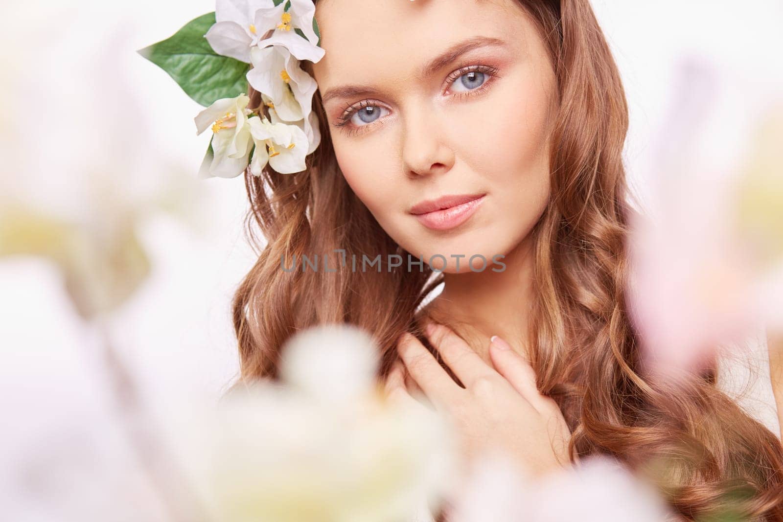 Charming girl looking at camera out of spring blossom