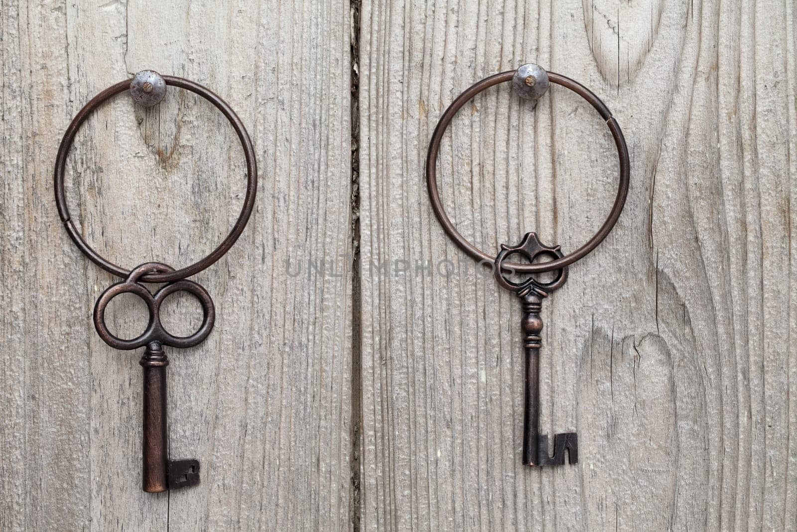 Old rusty key hanging on wooden wall