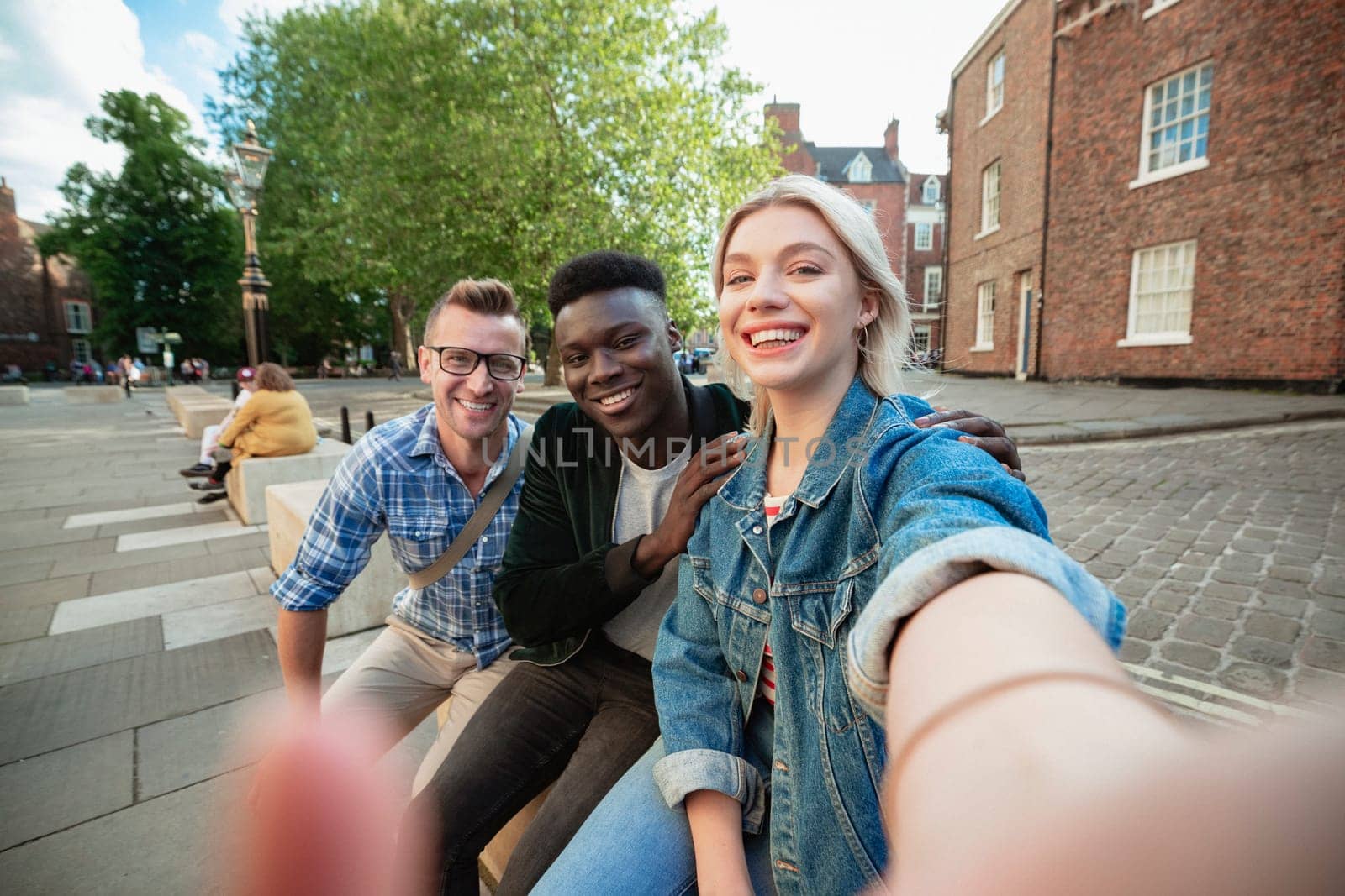 A selfie shot of two men and a woman, the woman is taking the selfie.