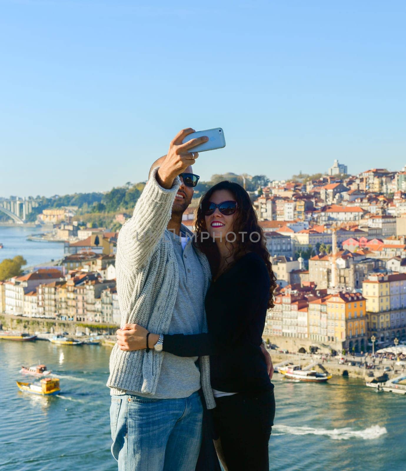 PORTO, PORTUGAL - Couple taking selfie in front of Old Town of Porto, Portugal