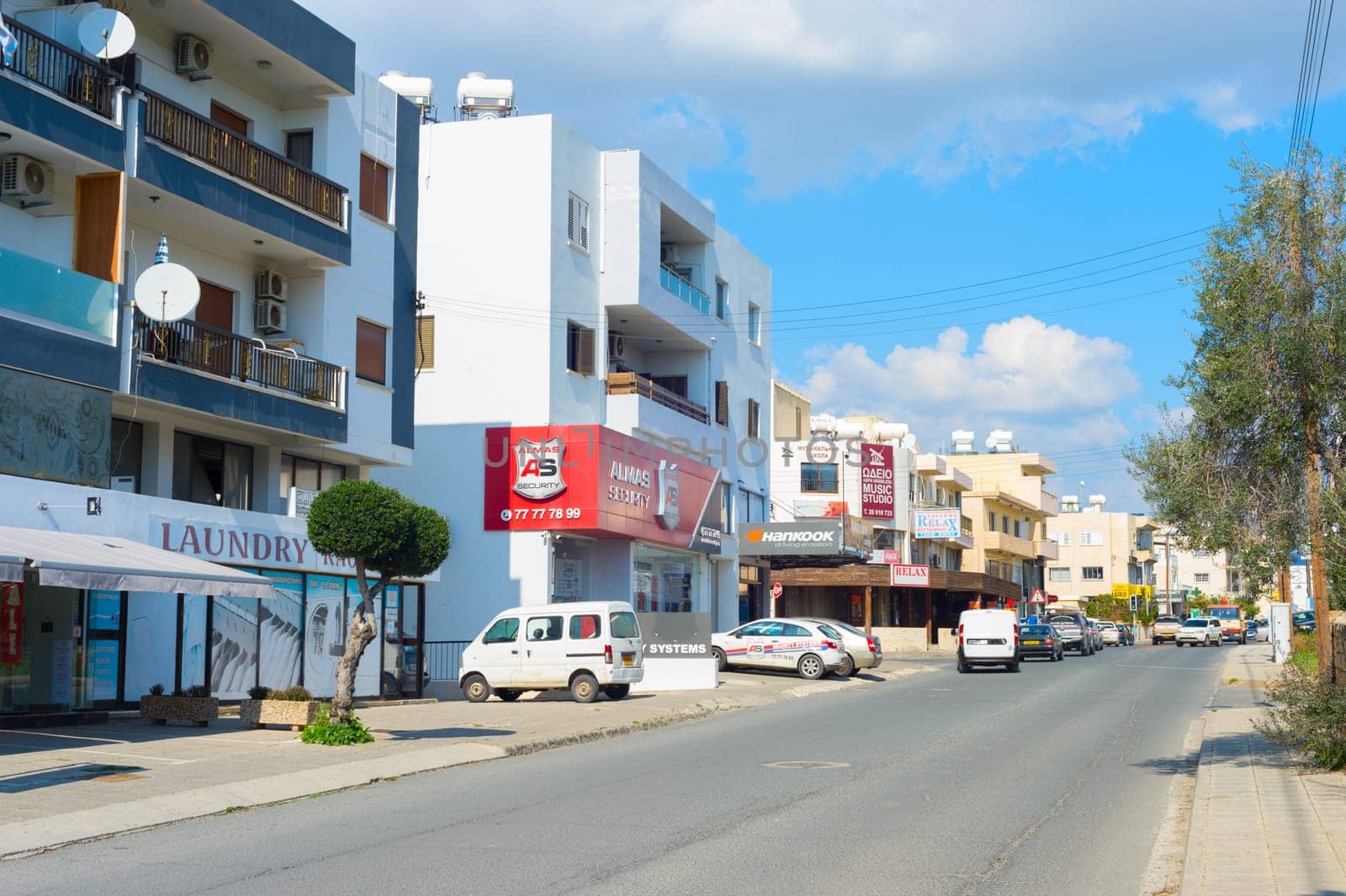 PAPHOS, CYPRUS - FEBRUARY 13, 2019: Road and typical residential district of Paphos. Paphos is the most famous city of Cyprus