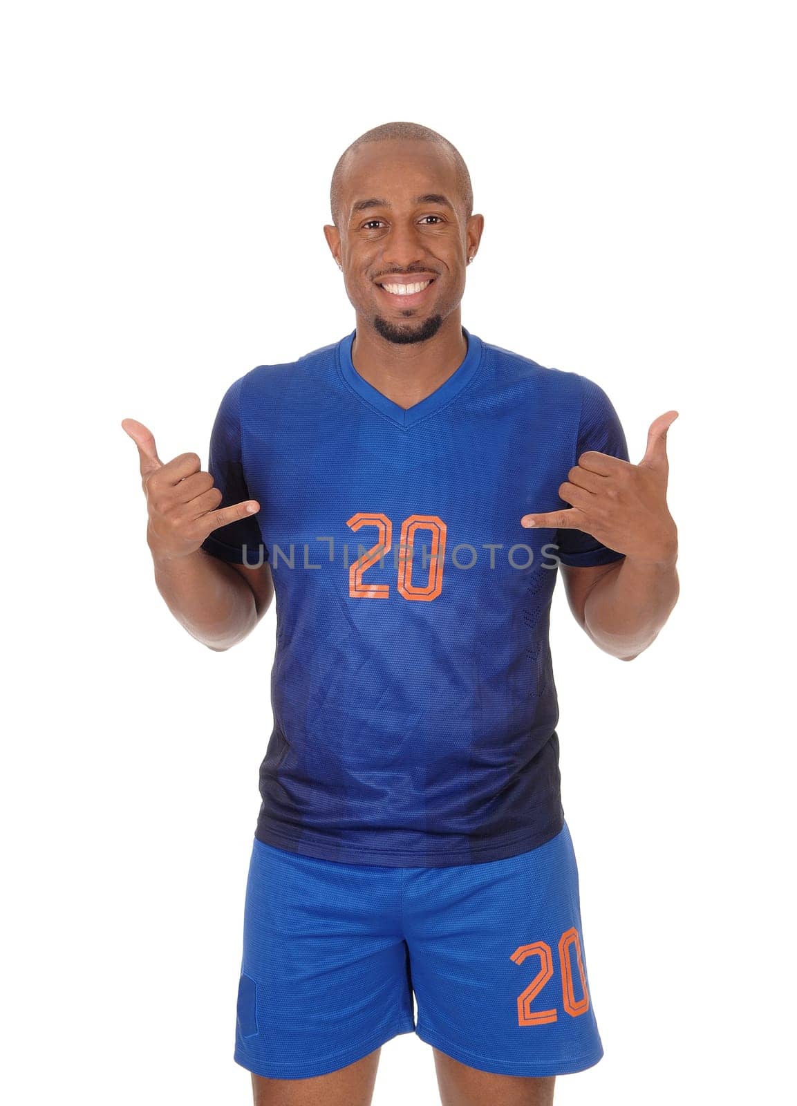 A young African American soccer player standing in the studio in his blue.uniform pointing to himself, isolated for white background.