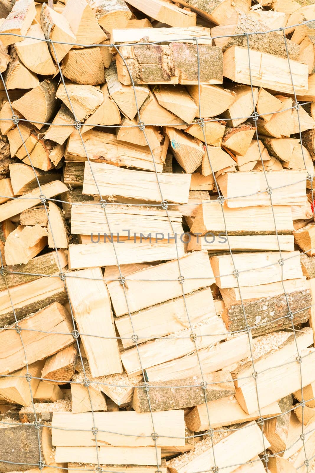 Logs in a metal grid cage on a lumber yard