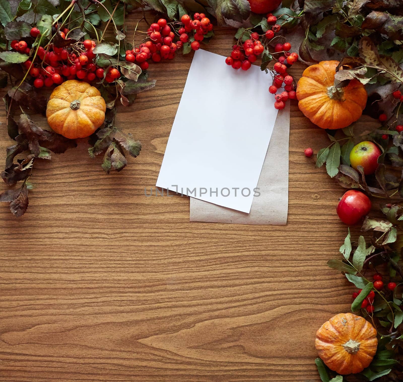 Autumn composition. Pumpkins, dried fall leaves, apples, red berries on wooden table. Flat lay, top view, copy space