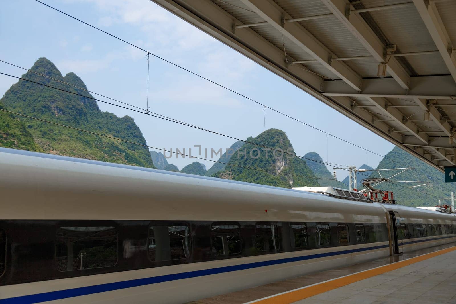 Fragment of a fast train at the station on the background of picturesque mountains, Yangshuo, China
