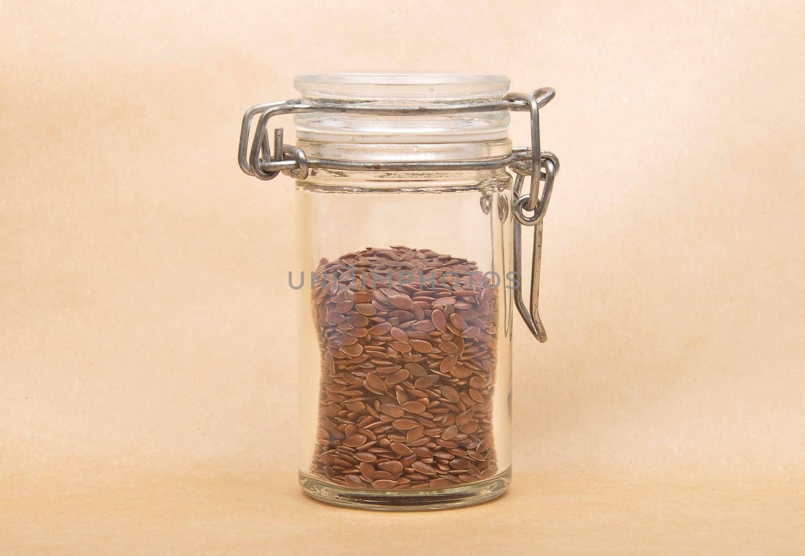 Linseed in glass on brown background