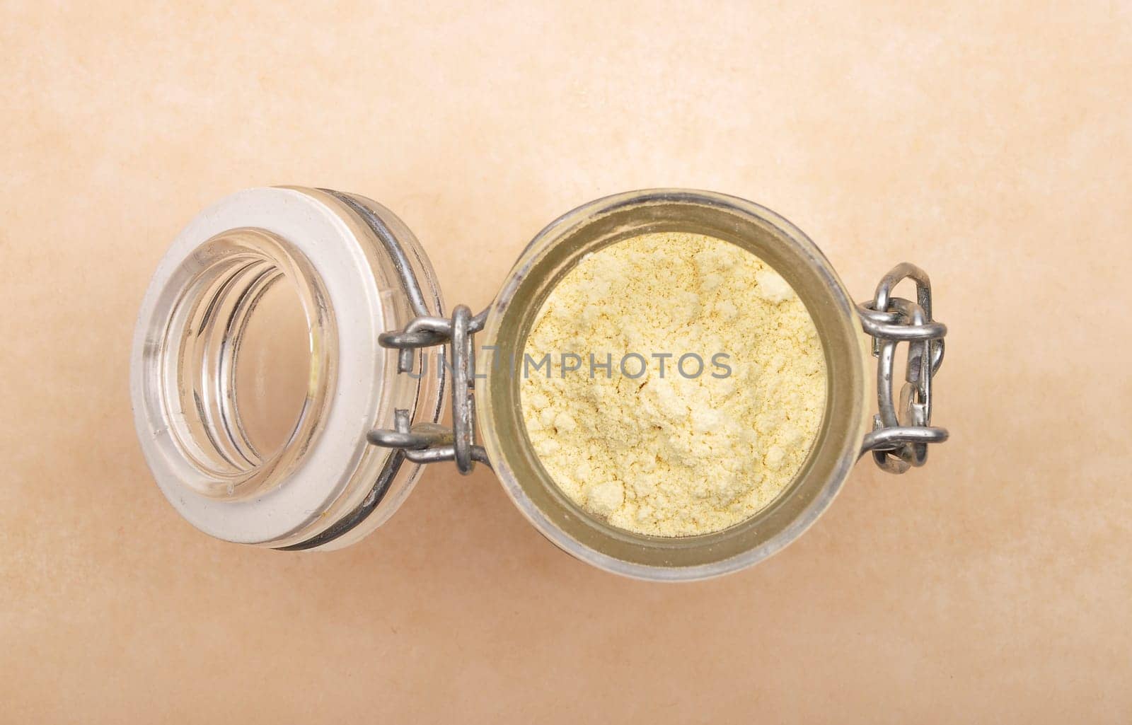 Lupin flour in open jar on brown background