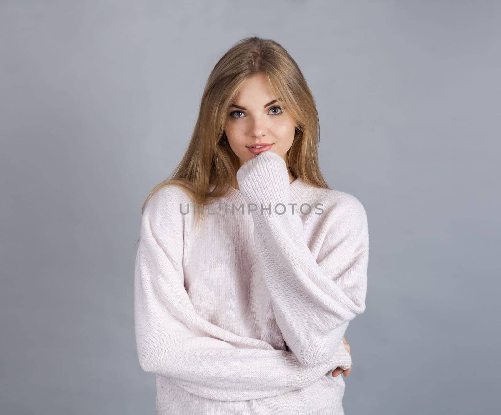 Young blonde girl, isolated on grey