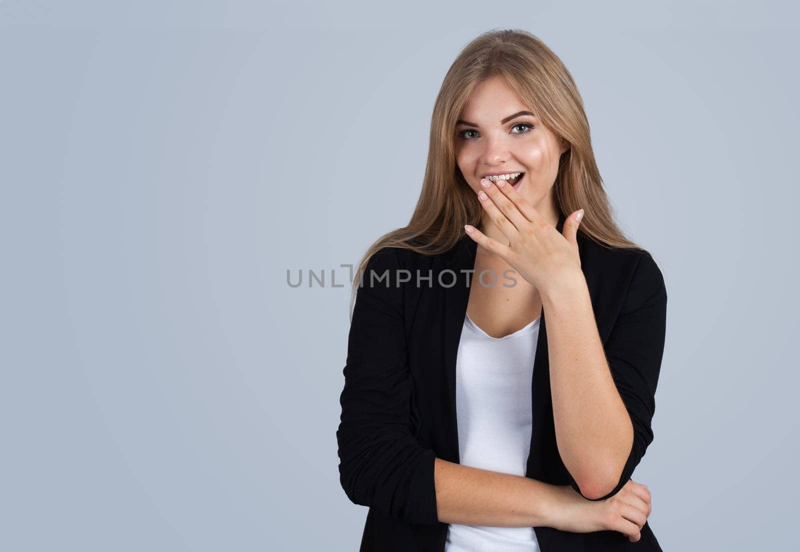 Young blonde woman amazed, copyspace, isolated on grey