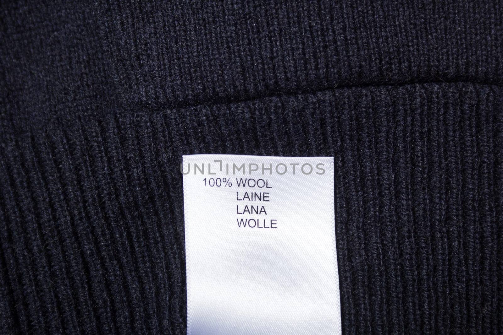 100 wool label on the sweater dark blue wool fabric.