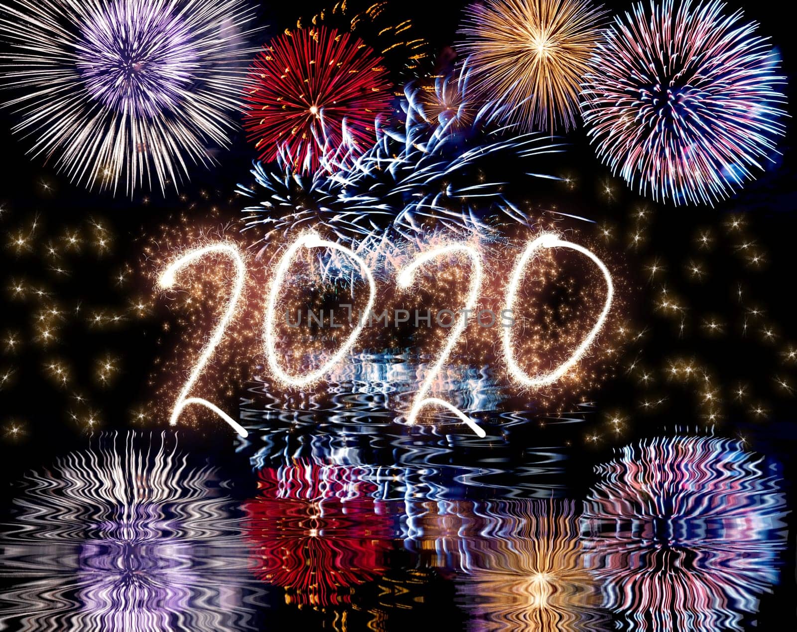 Colorful fireworks in the night sky with reflect in water and sparkling 2020 text