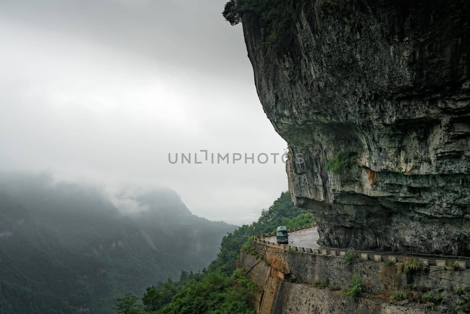 Small bus taking dangerous sharp turn on the winding road of 99 turns to the top of the Tianmen Mountain, Zhangjiajie