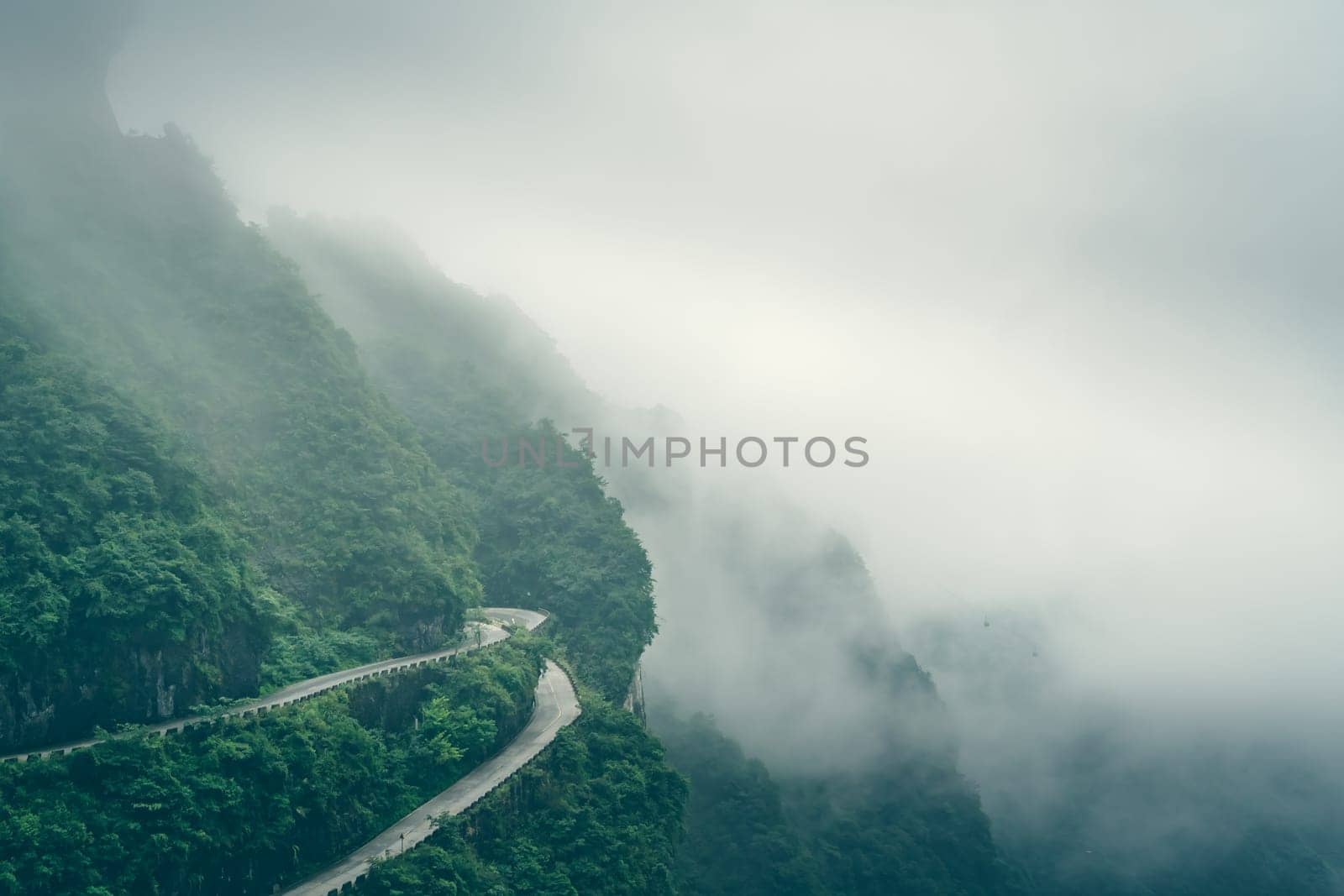 Covered by low clouds and mist dangerous sharp turns on the winding road of 99 turns to the top of the Tianmen Mountain, Zhangjiajie National Park, Hunan, China