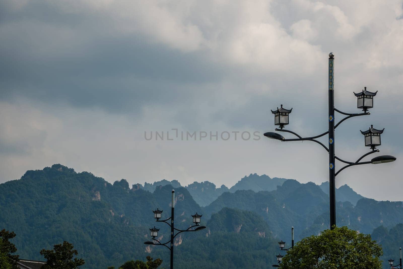 Lampposts on the street in Wulingyuan with the stunningly beautiful rocky karst mountain formations in the background, Hunan Province, China