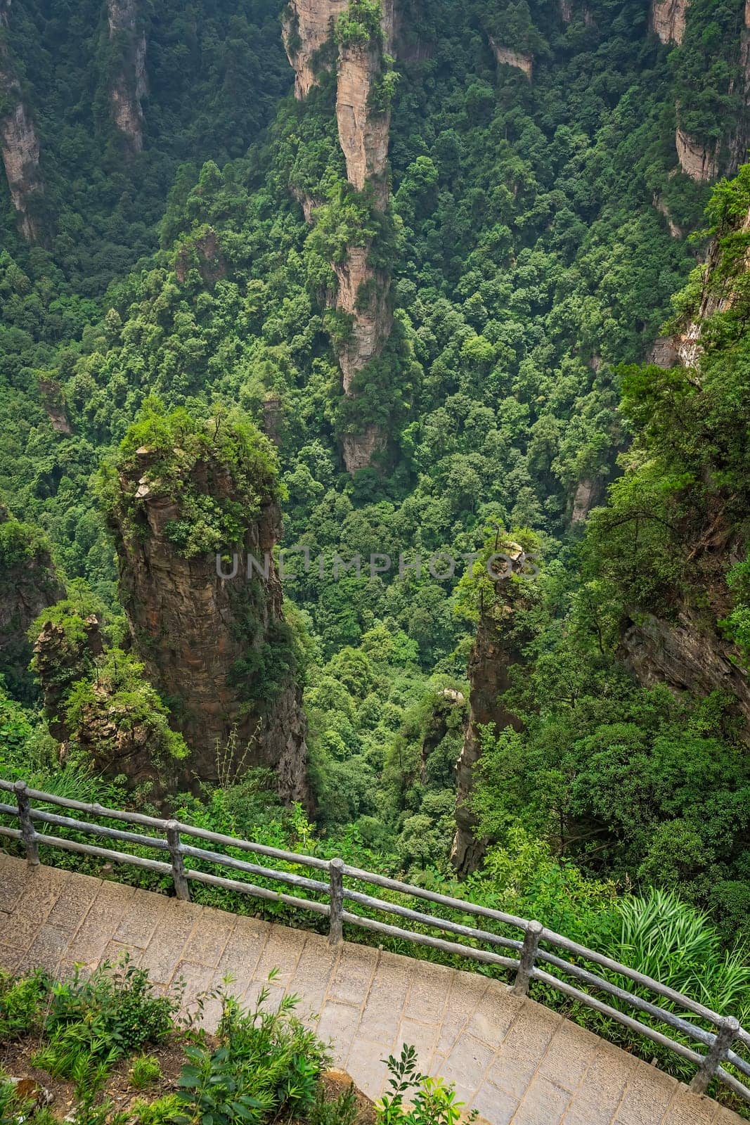 Vertical view of the walking path with spectacular views over stone pillars of Tianzi mountains and Greatest Natural Bridge in Zhangjiajie National park, famous tourist attraction, Wulingyuan, Hunan Province, China
