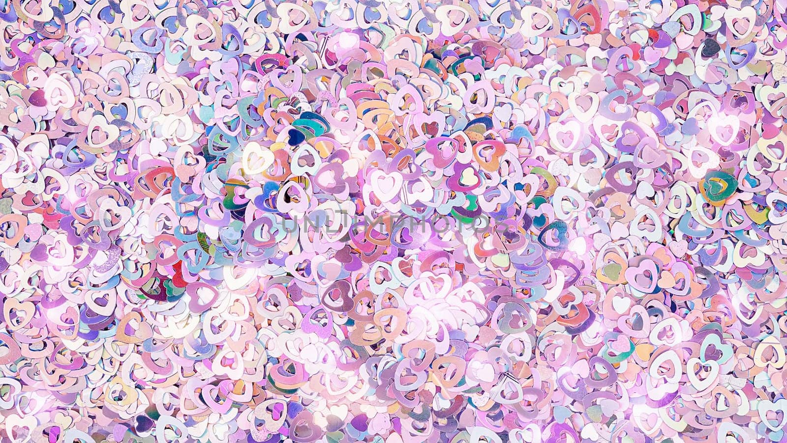 Real shiny heart-shaped sparkles textured background