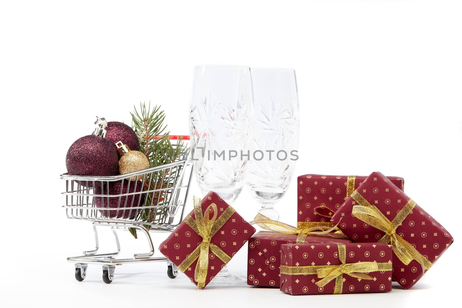 Shopping trolley, champagne flutes, gift boxes and Christmas decoration isolated on white background, Christmas and New Year shopping. Winter sale.