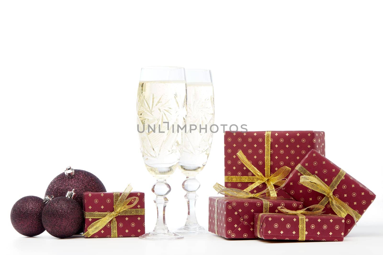 Still life with two champagne flutes, gift boxes and Christmas decoration isolated on white background with copy space. Christmas and New Year shopping. Greeting card