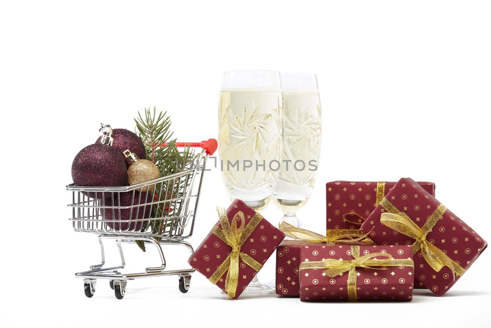Shopping trolley, champagne flutes, gift boxes and Christmas decoration isolated on white background, Christmas and New Year shopping. Winter sale.