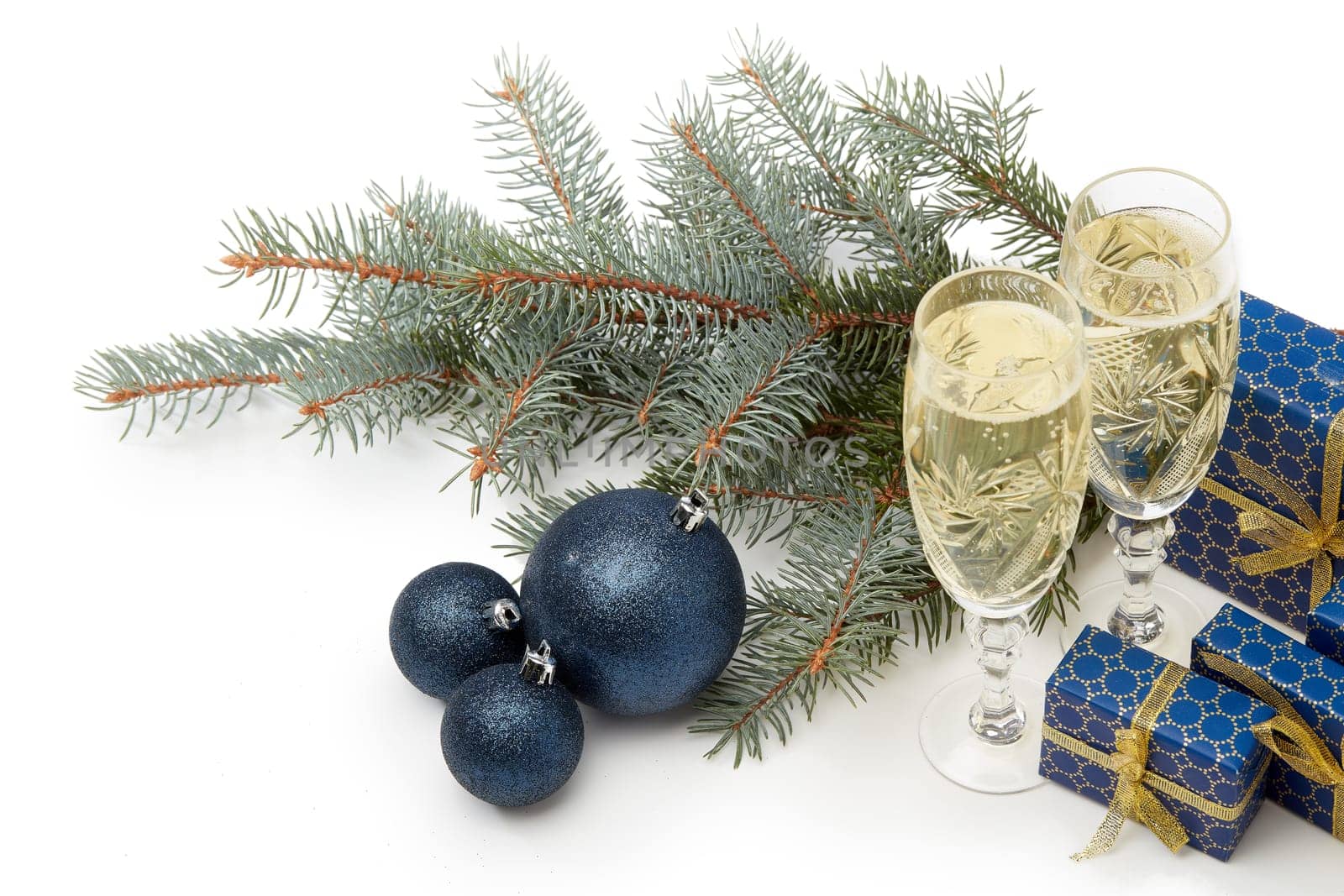 Still life with two champagne flutes, gift boxes and Christmas decoration with fir tree branch isolated on white background. Top view. Christmas and New Year shopping. Greeting card