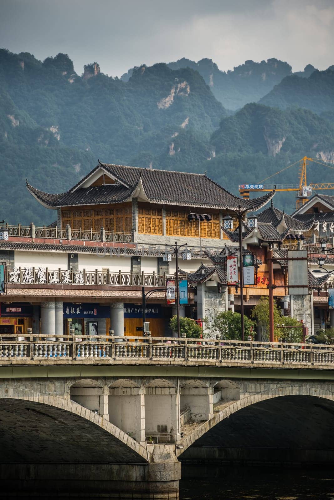 Wulingyuan, China - August 2019 : Wide arched bridge over Suoxiyu river in the ancient part of Wullingyuan town, Hunan Province