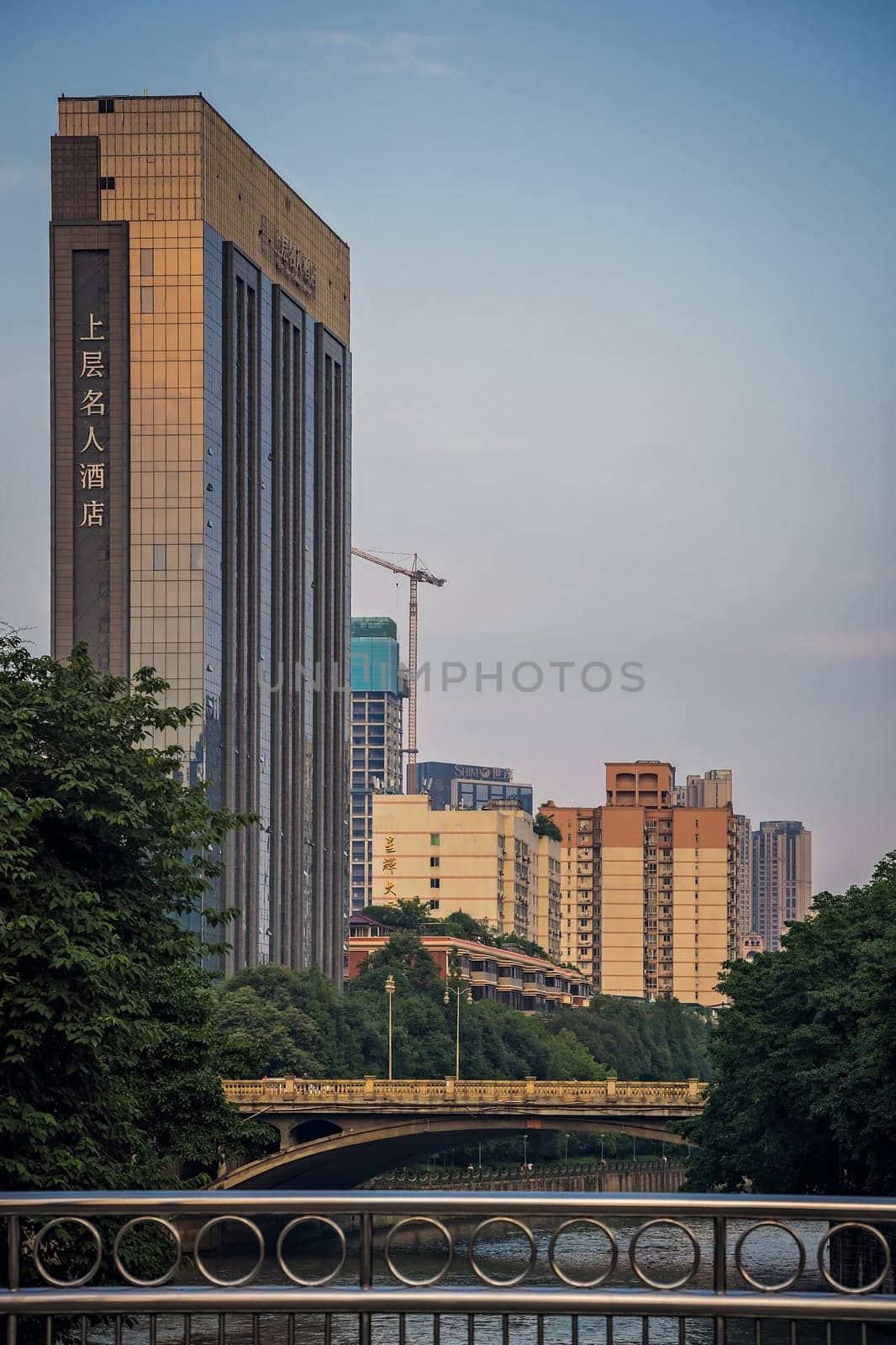 Chengdu, China -  July 2019 : High-rise building commercial hotel and bridges over Jin river in Chengdu city, Sichuan Province