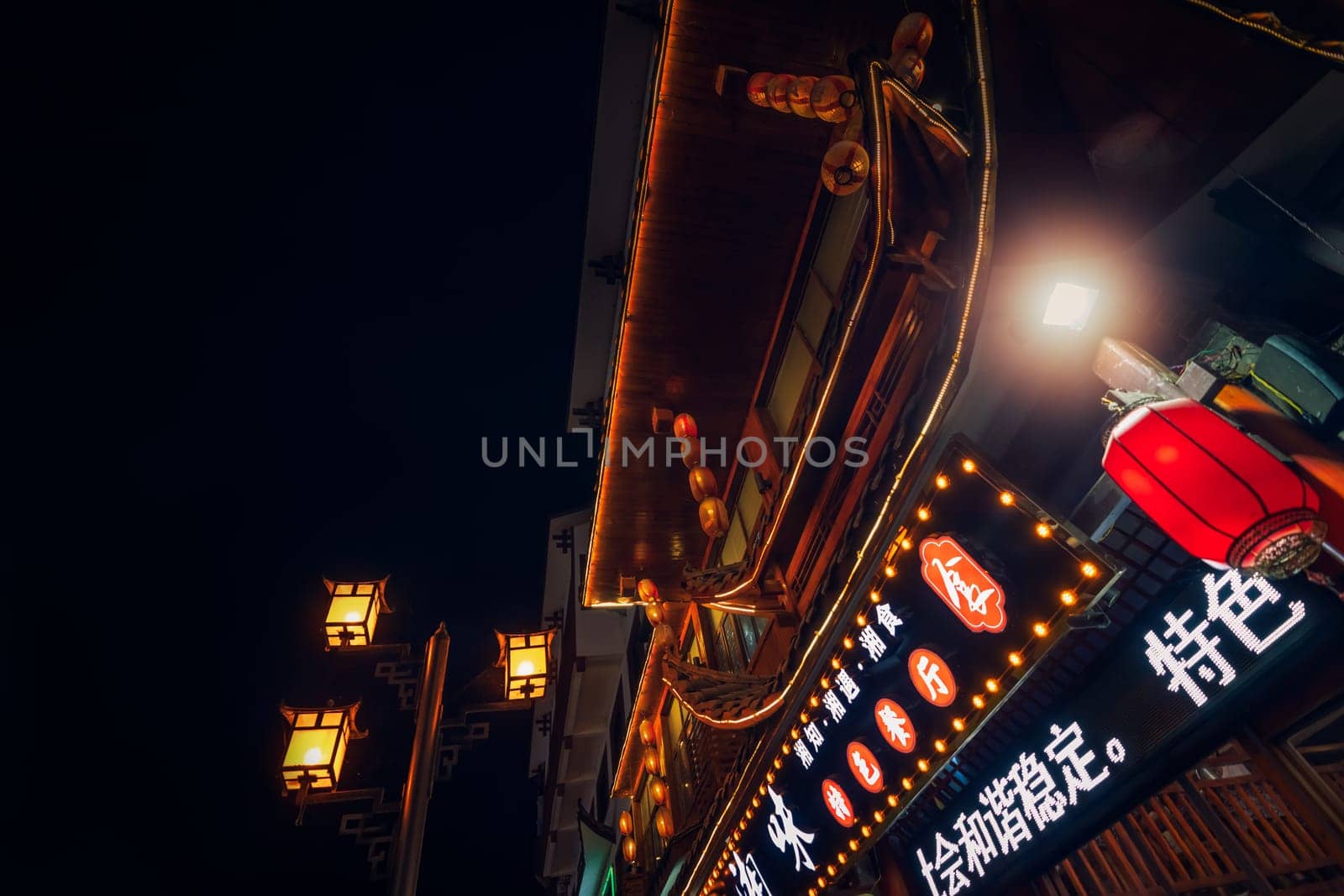 Wulingyuan, China - August 2019 : Advertising neon over chinese restaurant in bustling part of Wulingyuan town, Hunan Province