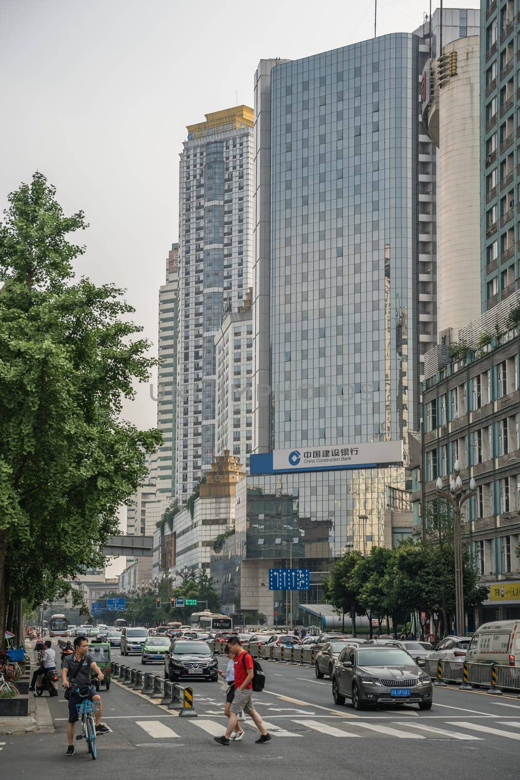 Chengdu, China -  July 2019 : People crossing the busy street in the commercial part of the city of Chengdu in summer, Sichuan Province