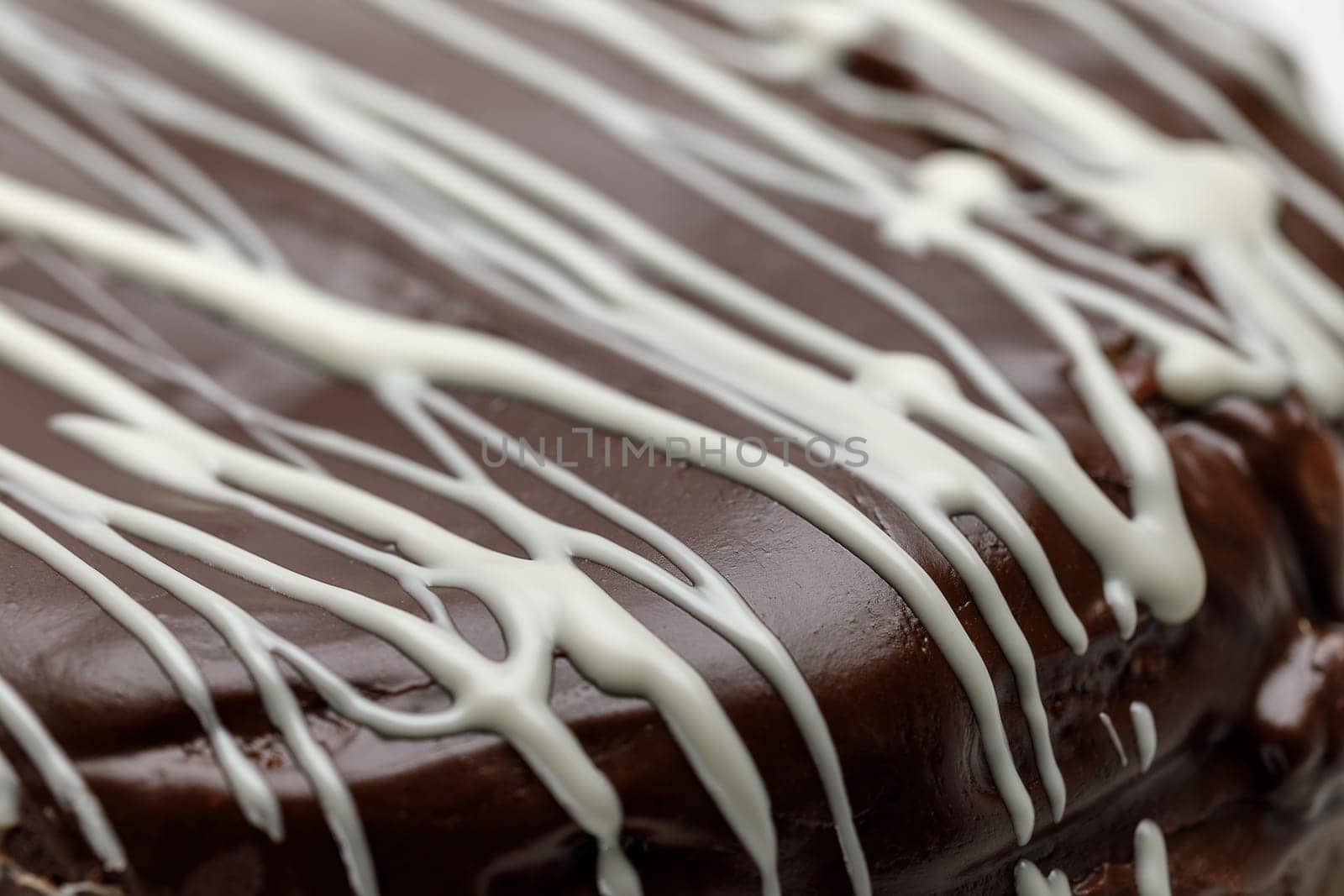 Homemade chocolate cake with chocolate glaze with white stripes on brown