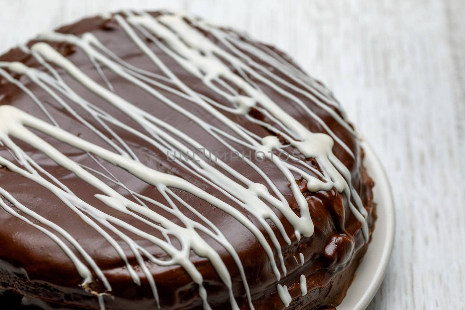 Homemade chocolate cake with chocolate glaze with white stripes on brown